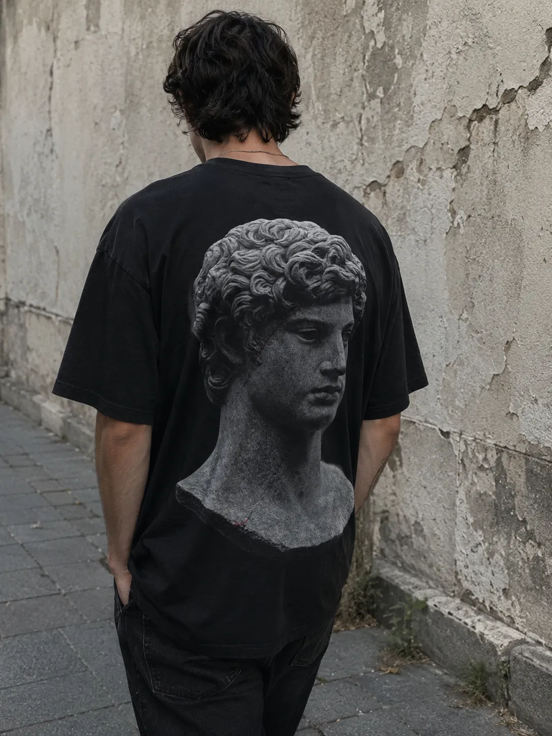 The WOUNDED tee worn, the print large across the back.
